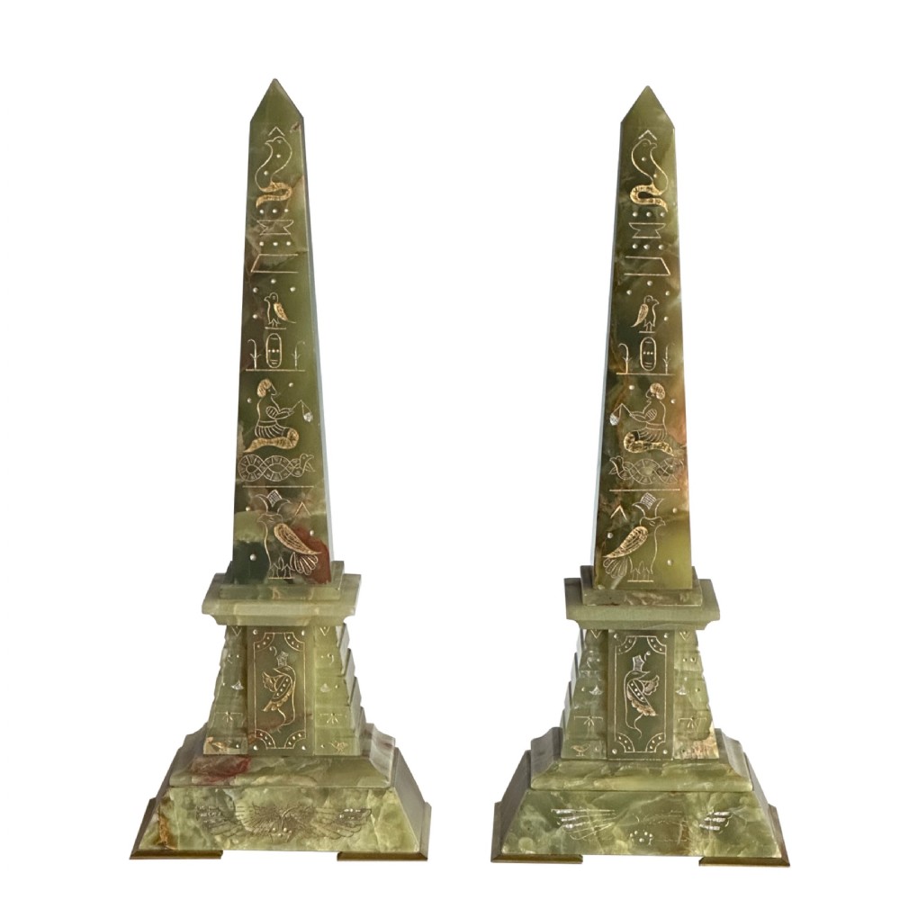 A pair of green onyx obelisks featuring hand-incised gilt Egyptian hieroglyphic details mounted on stepped rectangular bases.