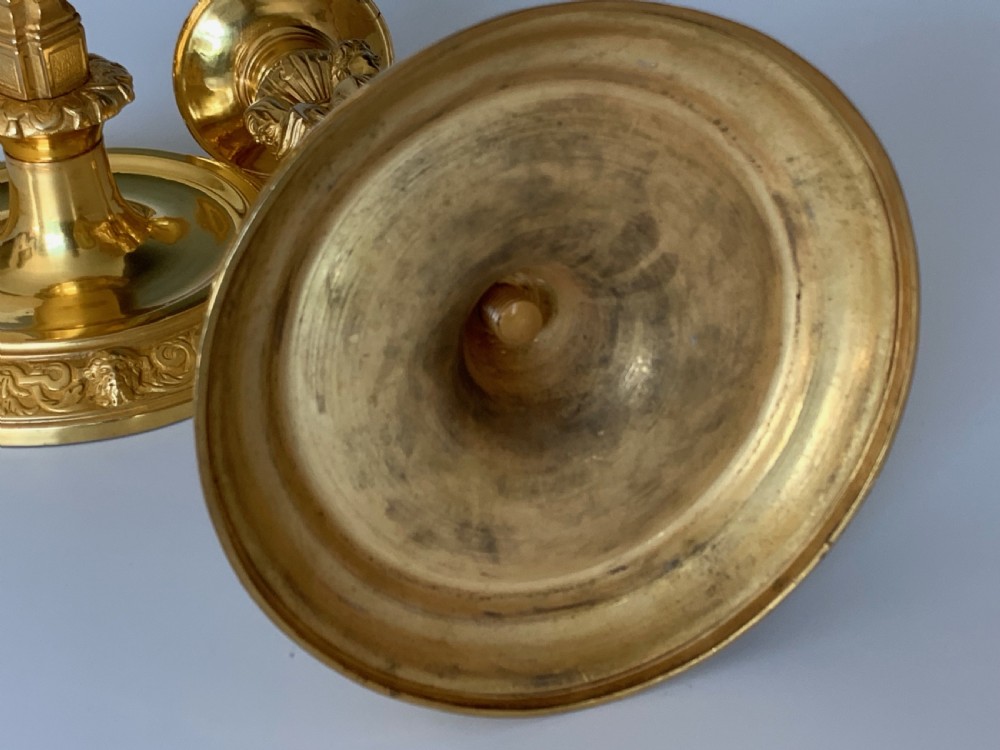 A pair of French Regence gilt bronze candlesticks featuring tapered columns decorated with allegorical term busts and circular chased bases. View VII