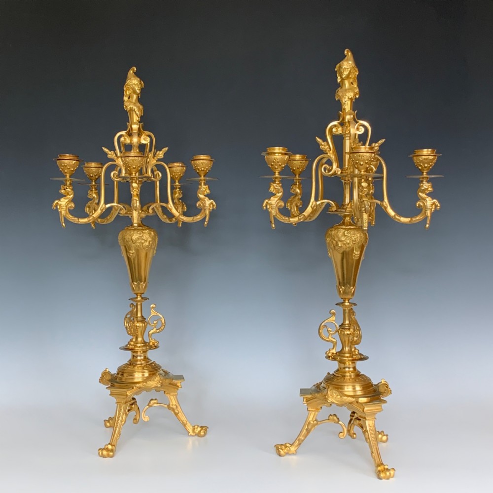 A pair of antique French ormolu five-branch candelabra featuring scrollwork arms, classical urn stems, and a gilded finish. View II