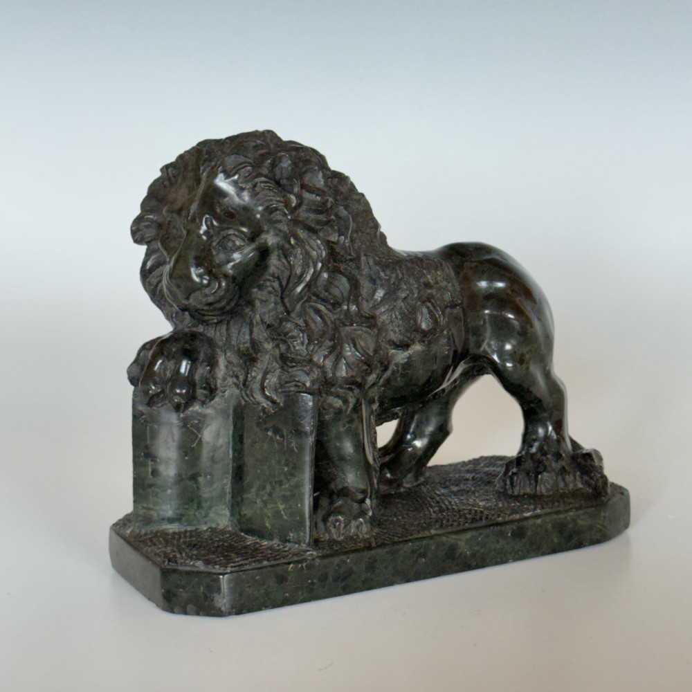 A dark green carved serpentine marble sculpture depicting the Lion of Saint Mark resting a paw on an upright book. View II