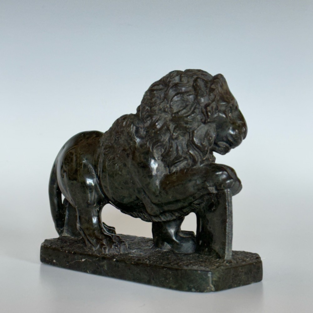 A dark green carved serpentine marble sculpture depicting the Lion of Saint Mark resting a paw on an upright book. View IV
