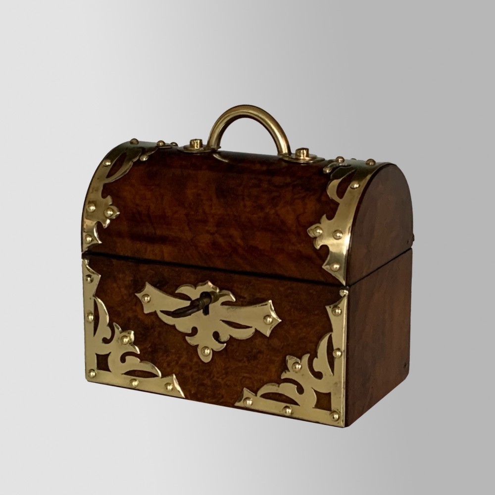 An open Victorian burr walnut scent casket with brass corner mounts containing two cut glass perfume bottles lined with blue fabric. View II