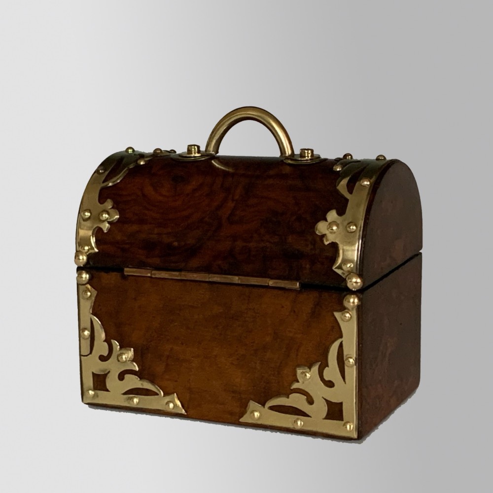 An open Victorian burr walnut scent casket with brass corner mounts containing two cut glass perfume bottles lined with blue fabric. View VI