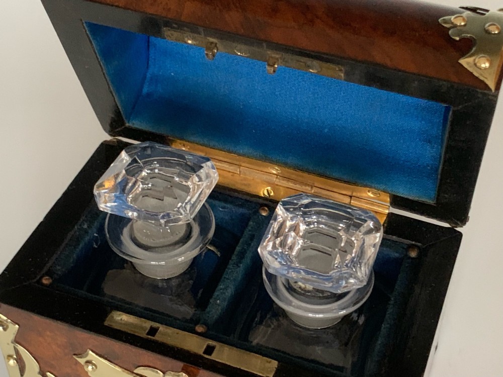 An open Victorian burr walnut scent casket with brass corner mounts containing two cut glass perfume bottles lined with blue fabric. View VII