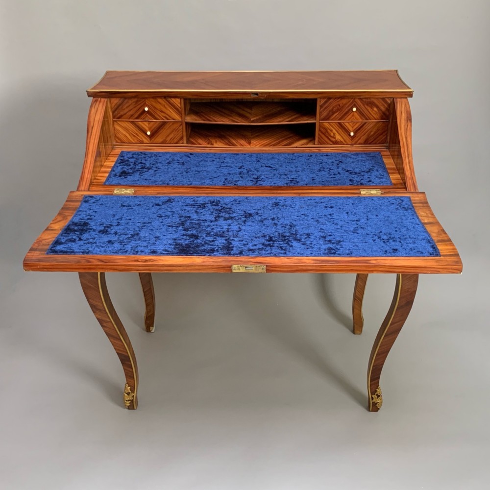 A 19th-century French Napoleon III tulipwood bureau featuring a slant top with brass inlay, ormolu mounts, and cabriole legs. View V