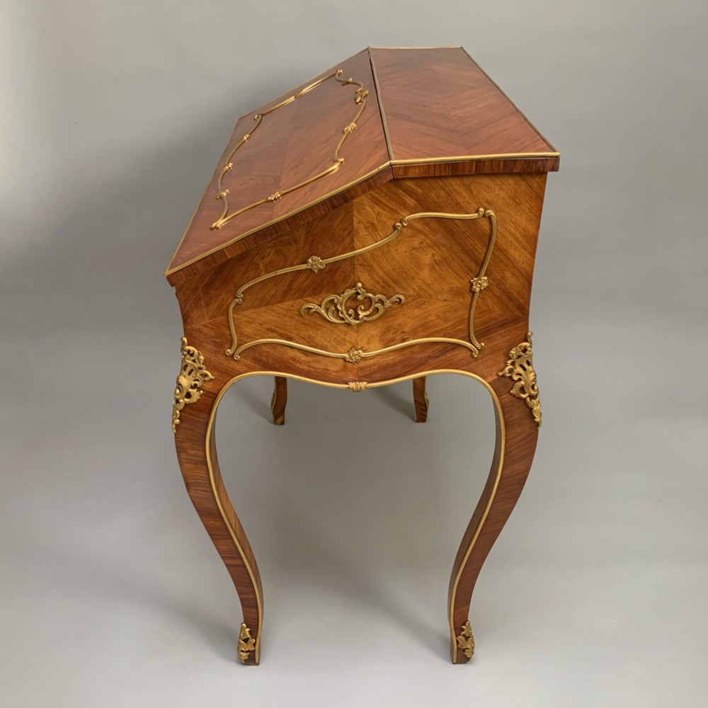 A 19th-century French Napoleon III tulipwood bureau featuring a slant top with brass inlay, ormolu mounts, and cabriole legs. View VIII