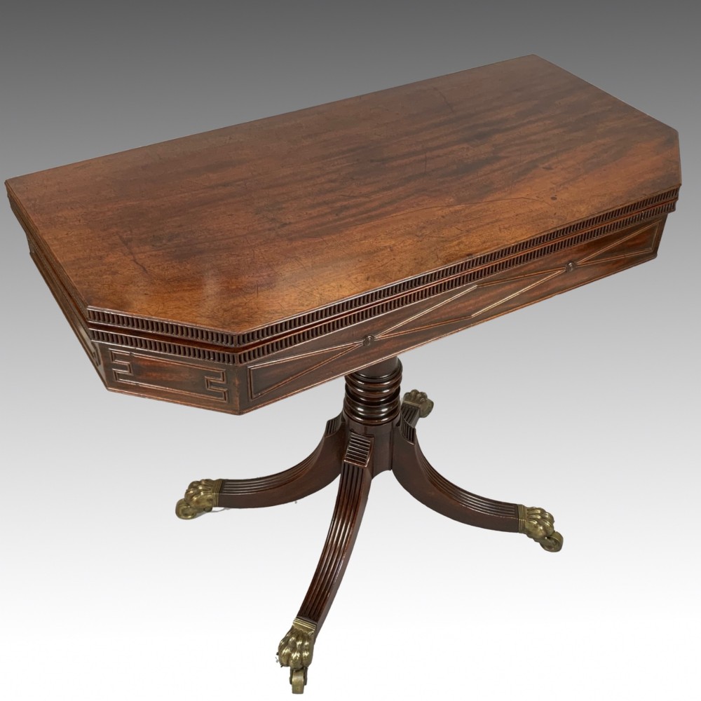 A George IV mahogany fold-over card table featuring a turned pedestal stem, geometric frieze inlay, and splayed legs with brass paw castors. View VII