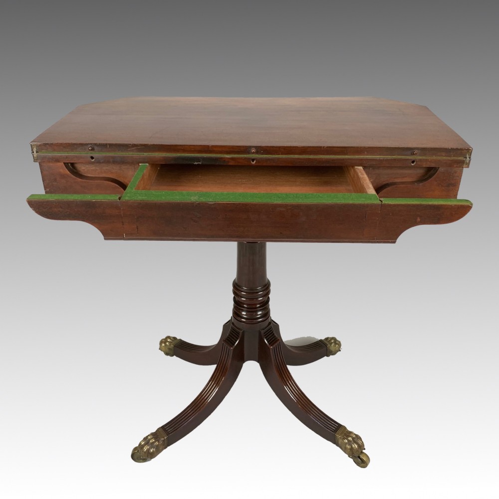 A George IV mahogany fold-over card table featuring a turned pedestal stem, geometric frieze inlay, and splayed legs with brass paw castors. View VIII