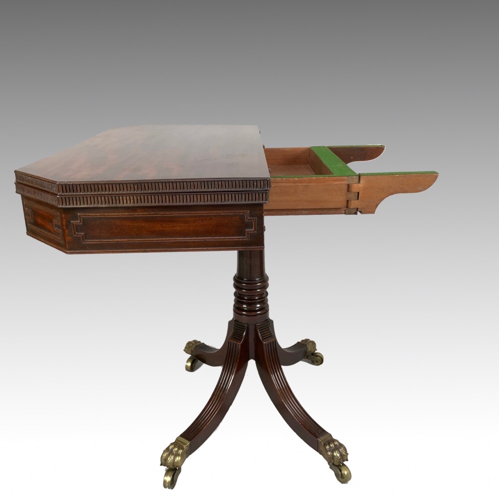 A George IV mahogany fold-over card table featuring a turned pedestal stem, geometric frieze inlay, and splayed legs with brass paw castors. View XI