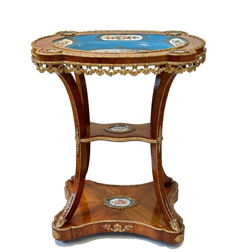 A French Napoleon III tulipwood gueridon featuring gilt-bronze mounts, a central blue Sevres-style porcelain top plaque, and two tiered shelves. View XI