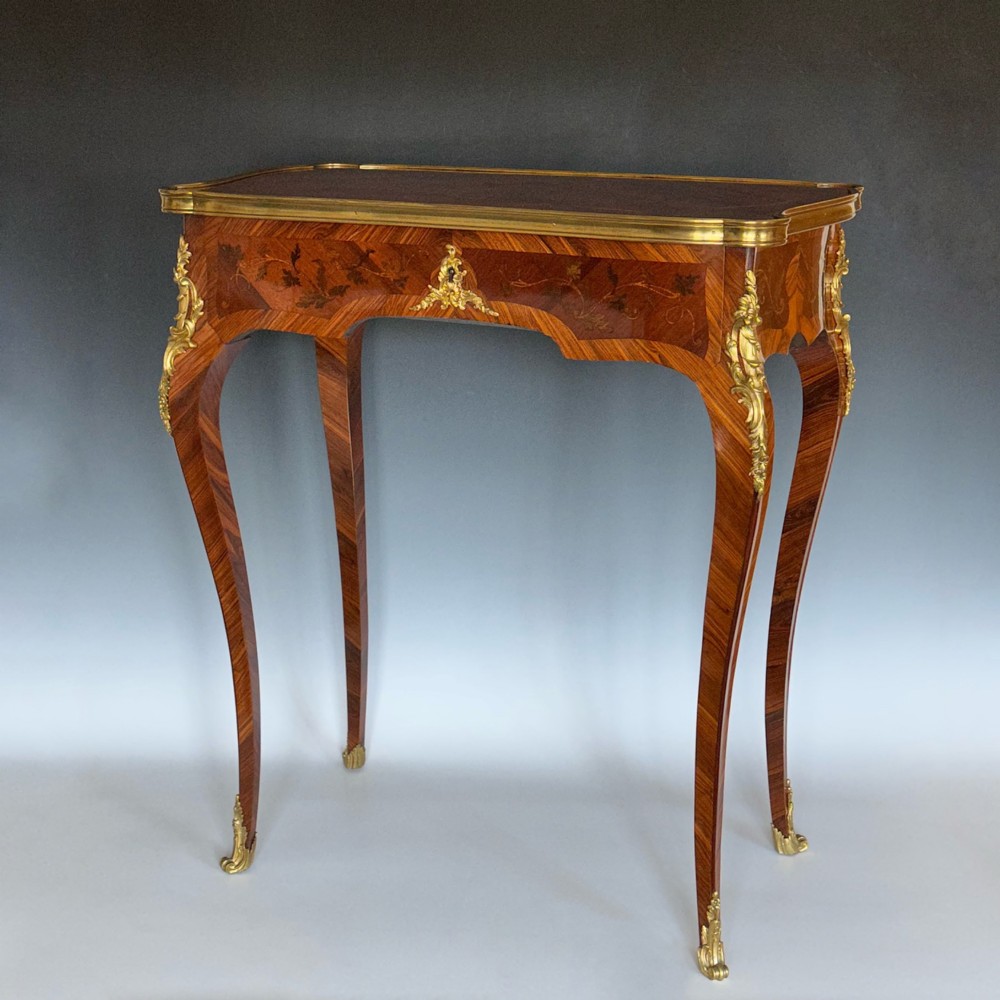 A French Louis XV style kingwood side table featuring floral marquetry inlay, slender cabriole legs, and ornate gilt bronze mounts.