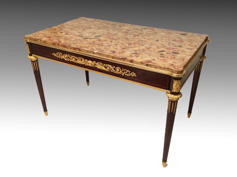A rectangular Louis XVI style centre table featuring a variegated marble top, dark mahogany frieze with elaborate gilt bronze mounts, and four fluted tapered legs. View II