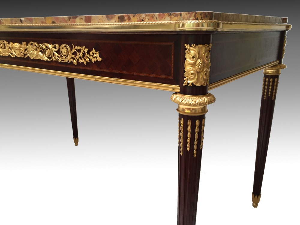 A rectangular Louis XVI style centre table featuring a variegated marble top, dark mahogany frieze with elaborate gilt bronze mounts, and four fluted tapered legs. View III