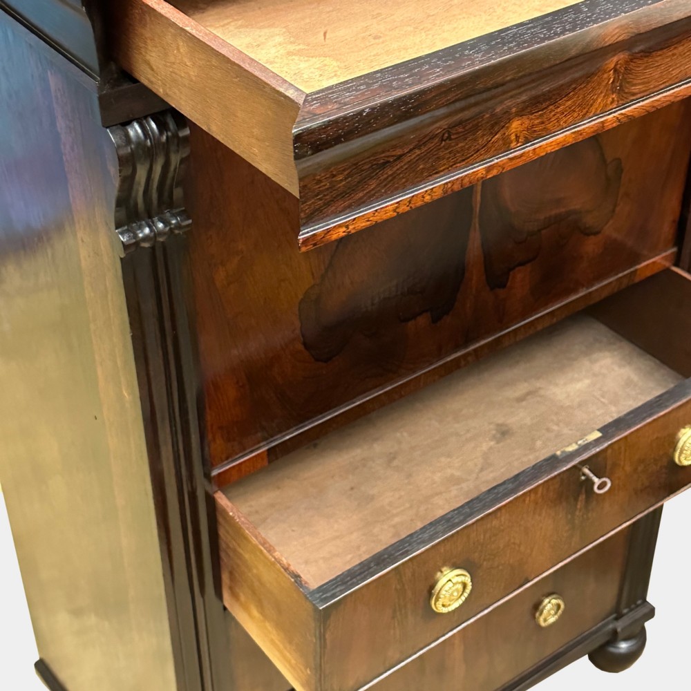 A George IV rosewood writing cabinet with a open fall-front desk revealing internal drawers and a dark green leather writing surface above lower drawers with brass handles. View VII