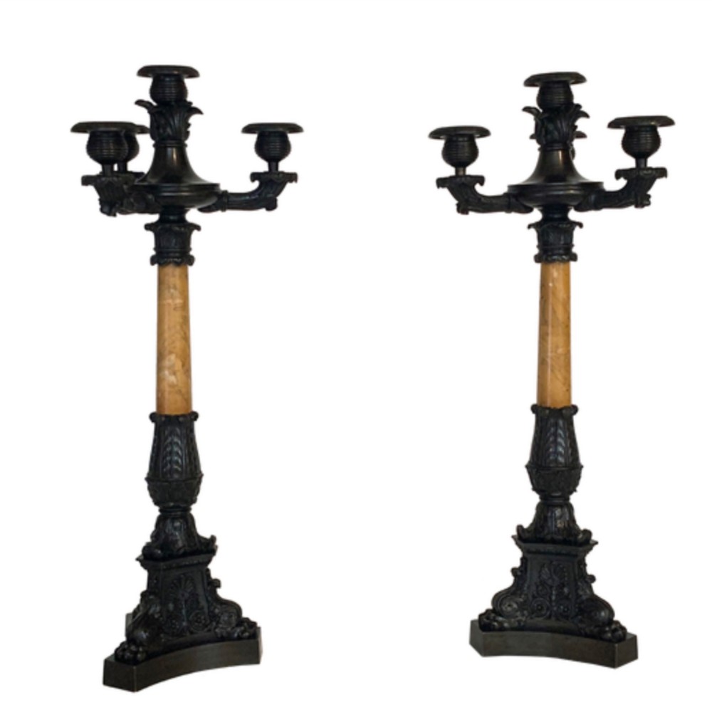 A pair of French Restoration period dark bronze candelabra with four candle branches each, supported by cylindrical yellow marble columns on detailed cast bronze tripartite bases. View III