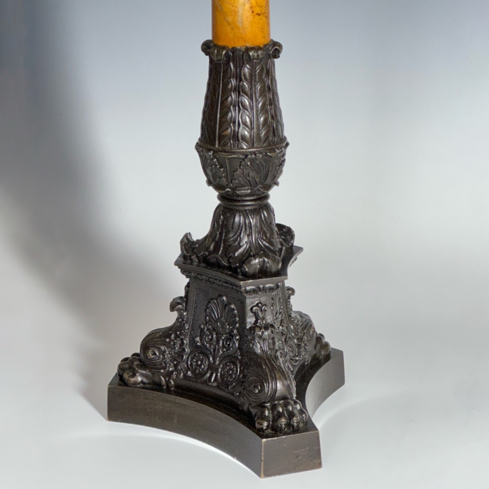 A pair of French Restoration period dark bronze candelabra with four candle branches each, supported by cylindrical yellow marble columns on detailed cast bronze tripartite bases. View IV
