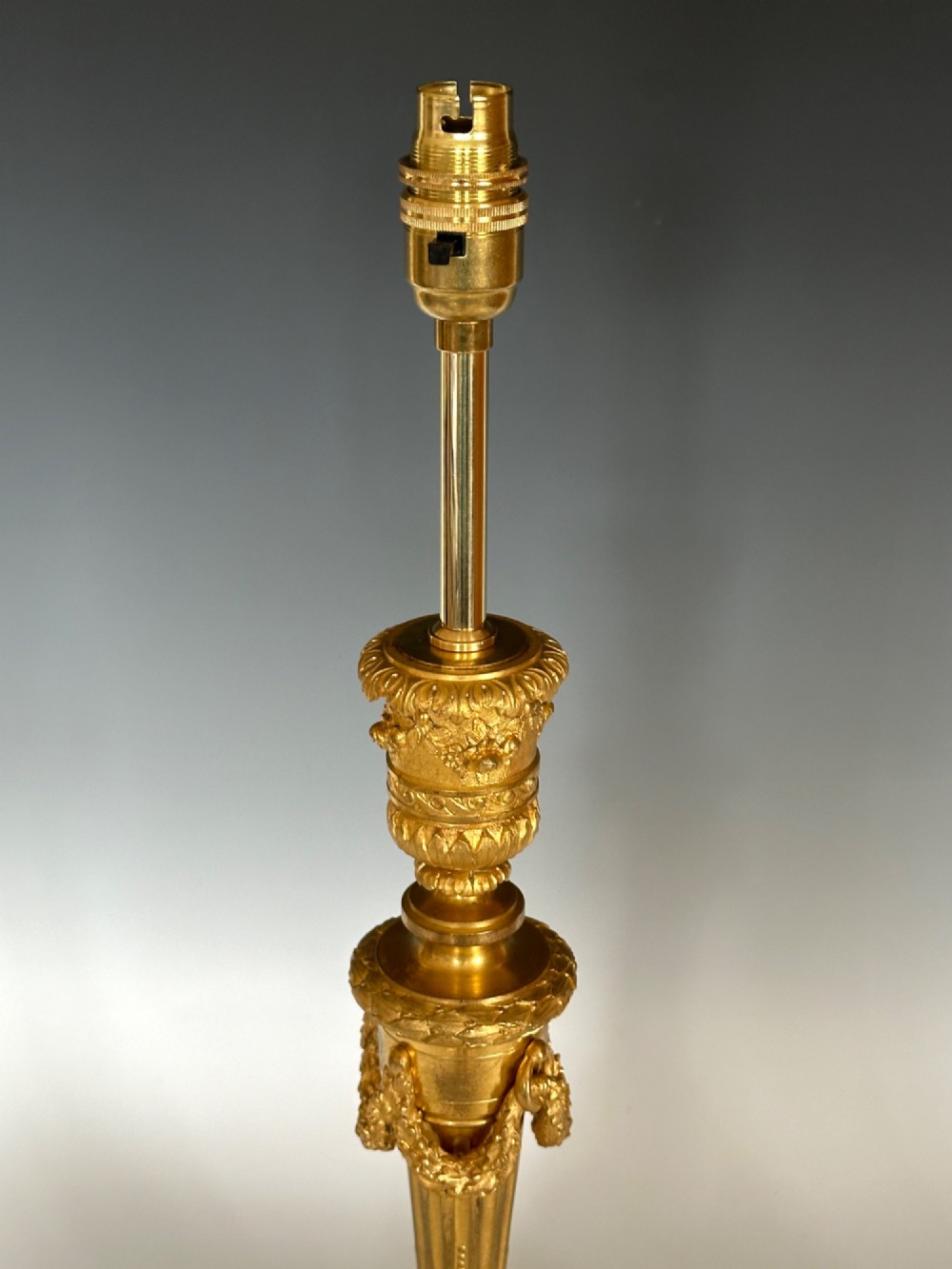 A Louis XV style gilt bronze ormolu table lamp featuring cast foliage swags, acanthus leaf detailing, and a circular white marble base. View V