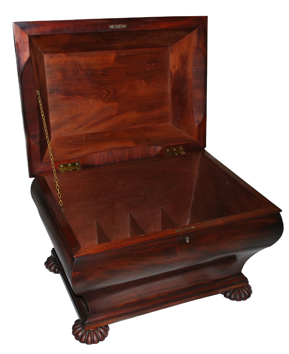 A George IV mahogany cellarette featuring a sarcophagus shape, stepped hinged lid, brass escutcheon, and carved lobed feet. View IV
