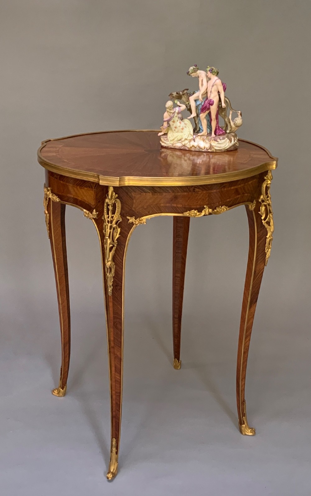 A nineteenth-century French kingwood occasional table featuring quarter-veneered parquetry, slender cabriole legs, and decorative gilt-bronze mounts. View V