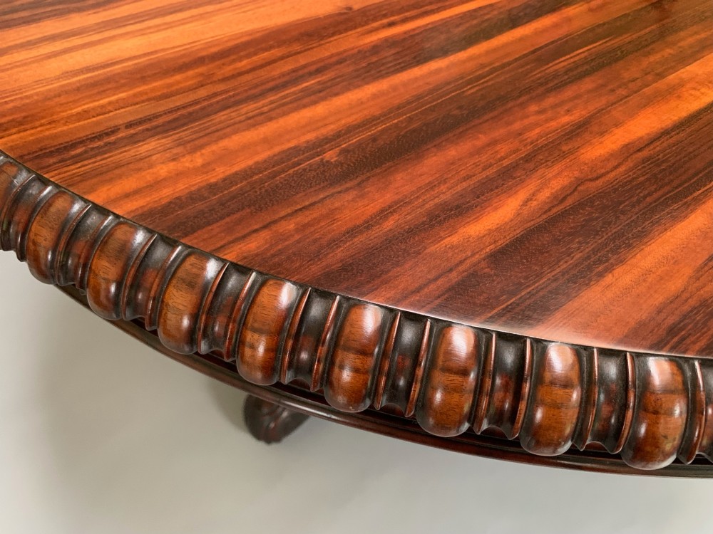 A 19th-century William IV oval centre table constructed from figured albuera wood with a gadrooned rim and a turned pedestal base. View II
