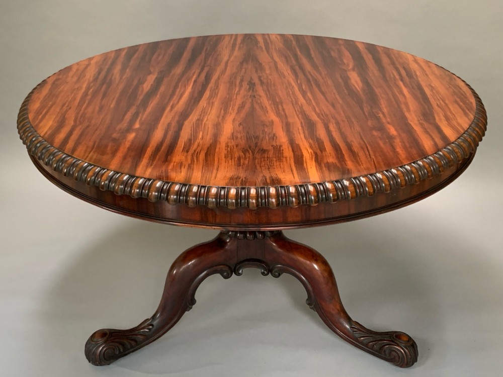 A 19th-century William IV oval centre table constructed from figured albuera wood with a gadrooned rim and a turned pedestal base. View VI