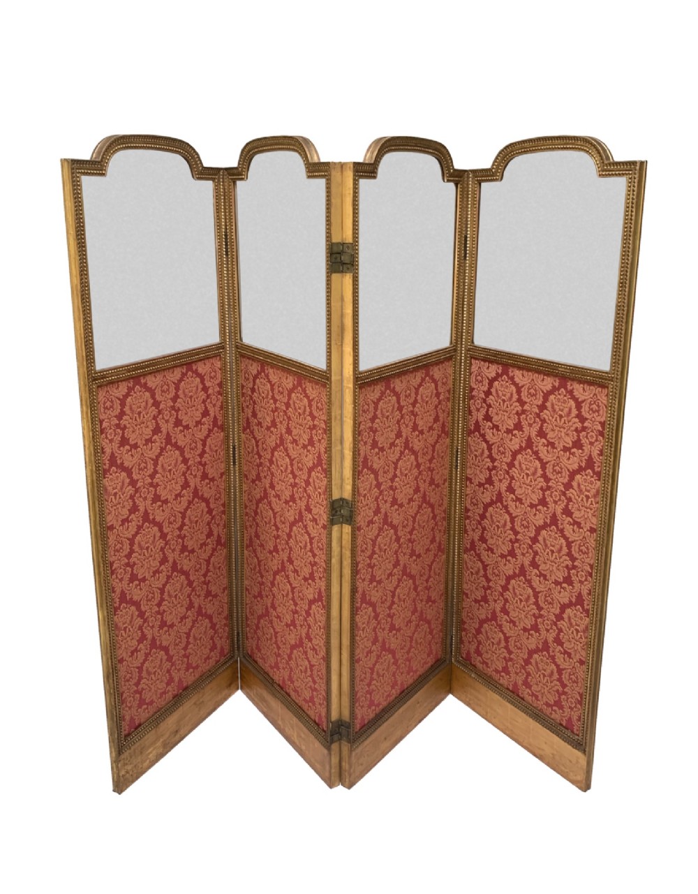 A Victorian four-fold screen featuring carved giltwood frames with arched tops, upper neutral panels, lower red and gold damask fabric panels, and brass hinges.