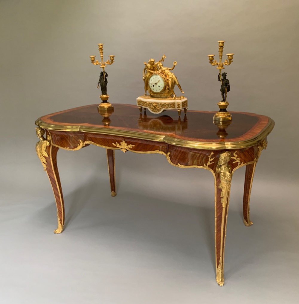 A French Louis XV style kingwood and rosewood centre table featuring serpentine edges, cabriole legs, and gilt-bronze mounts with female bust caryatids. View II