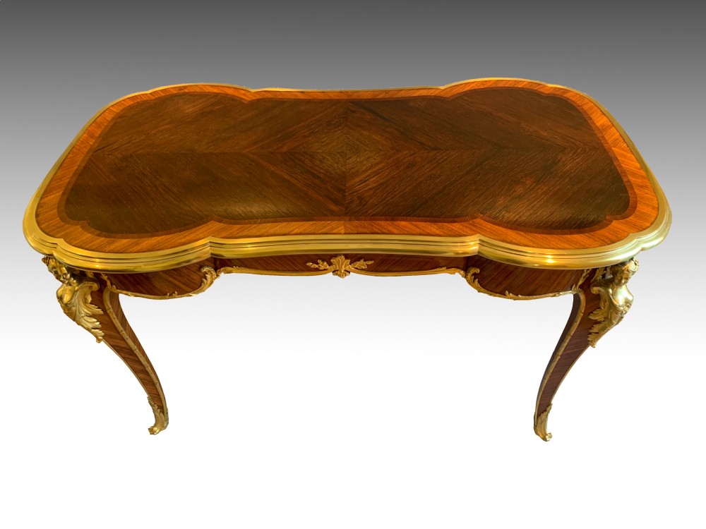 A French Louis XV style kingwood and rosewood centre table featuring serpentine edges, cabriole legs, and gilt-bronze mounts with female bust caryatids. View VIII