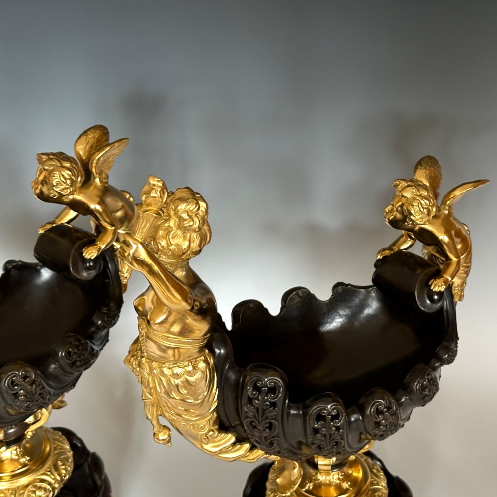 A pair of antique French gilt and patinated bronze centrepiece bowls mounted on red marble bases, decorated with sculpted cherubs and female figures holding torches. View VII