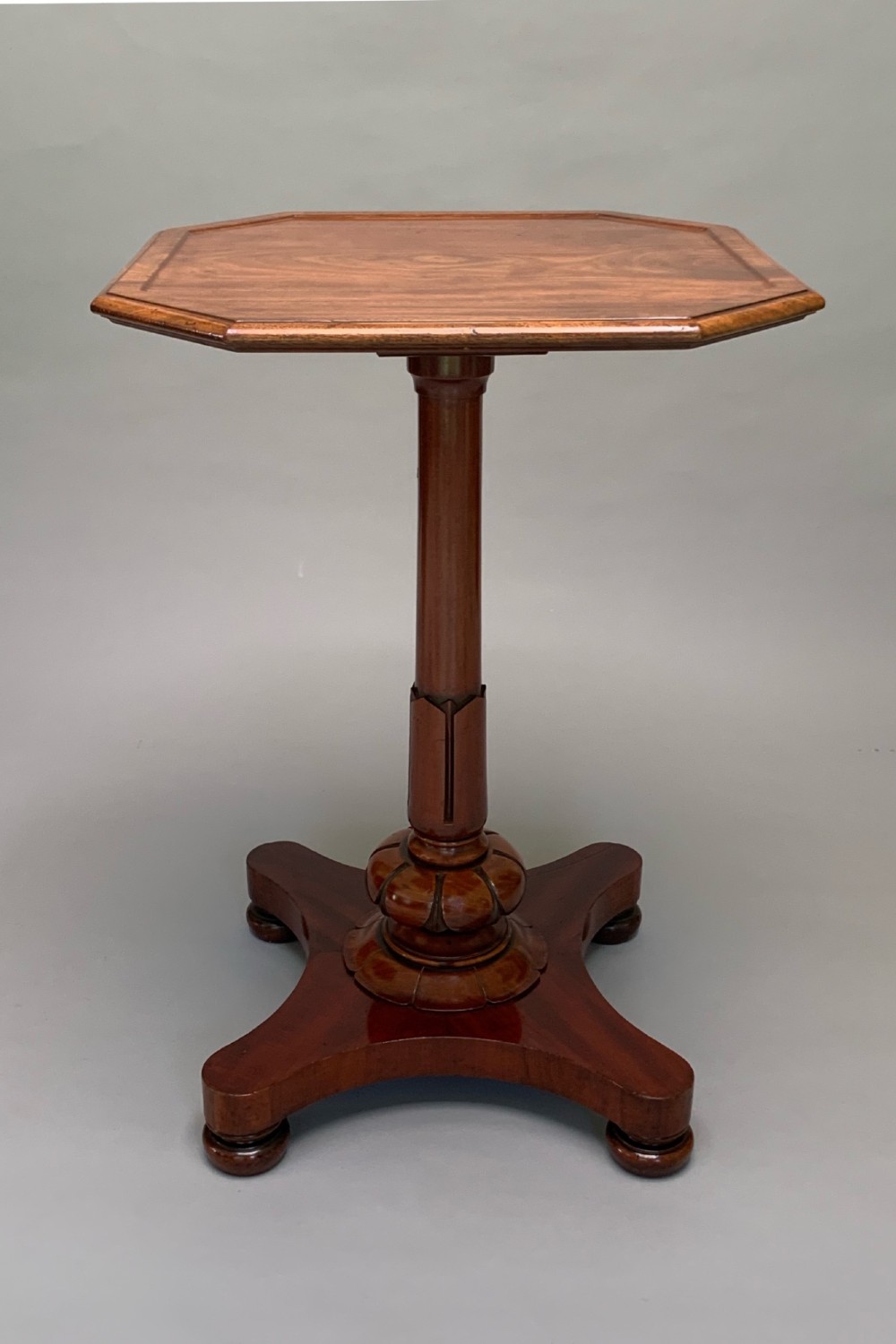 A Victorian mahogany side table with an octagonal top, turned pedestal stem, and carved quadripartite base. View II