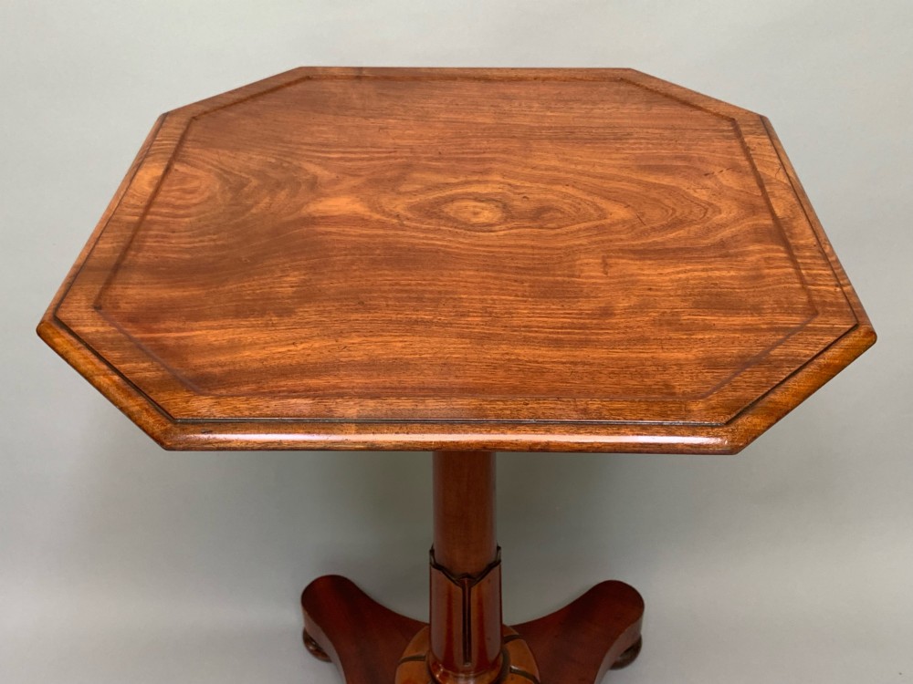 A Victorian mahogany side table with an octagonal top, turned pedestal stem, and carved quadripartite base. View IV