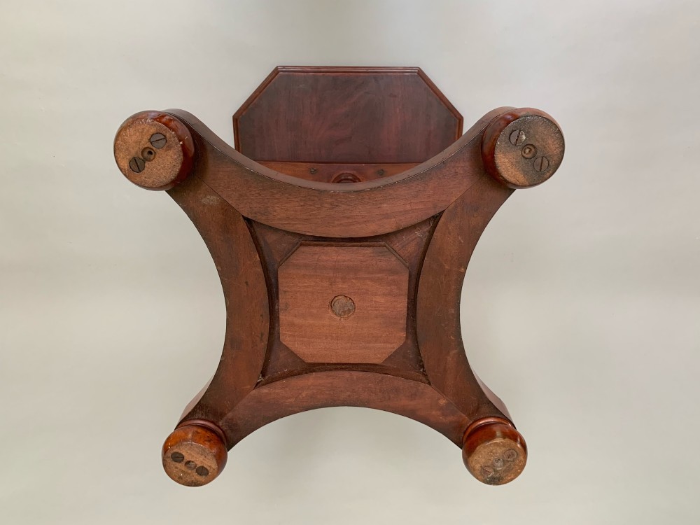 A Victorian mahogany side table with an octagonal top, turned pedestal stem, and carved quadripartite base. View V