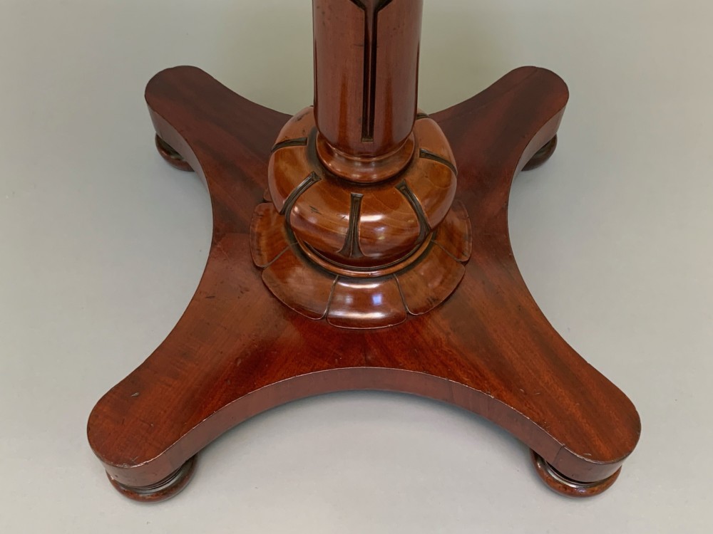A Victorian mahogany side table with an octagonal top, turned pedestal stem, and carved quadripartite base. View VIII