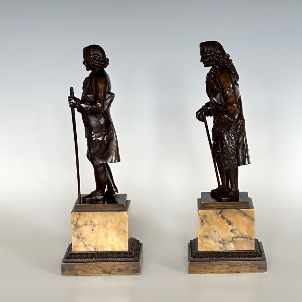 A pair of 19th-century French Restauration period patinated bronze statues of Voltaire and Rousseau mounted on yellow marble bases. View II