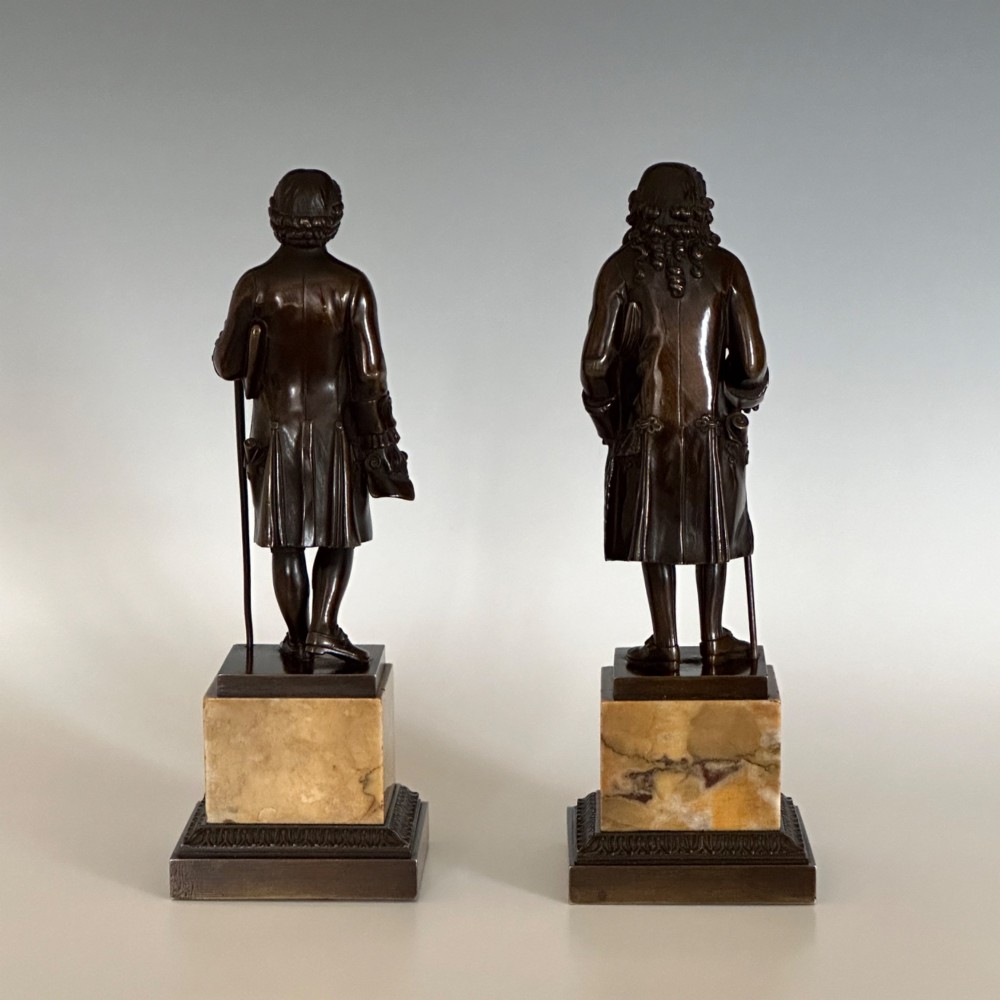A pair of 19th-century French Restauration period patinated bronze statues of Voltaire and Rousseau mounted on yellow marble bases. View III