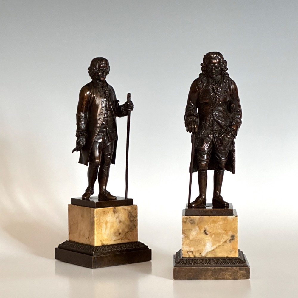 A pair of 19th-century French Restauration period patinated bronze statues of Voltaire and Rousseau mounted on yellow marble bases. View IV