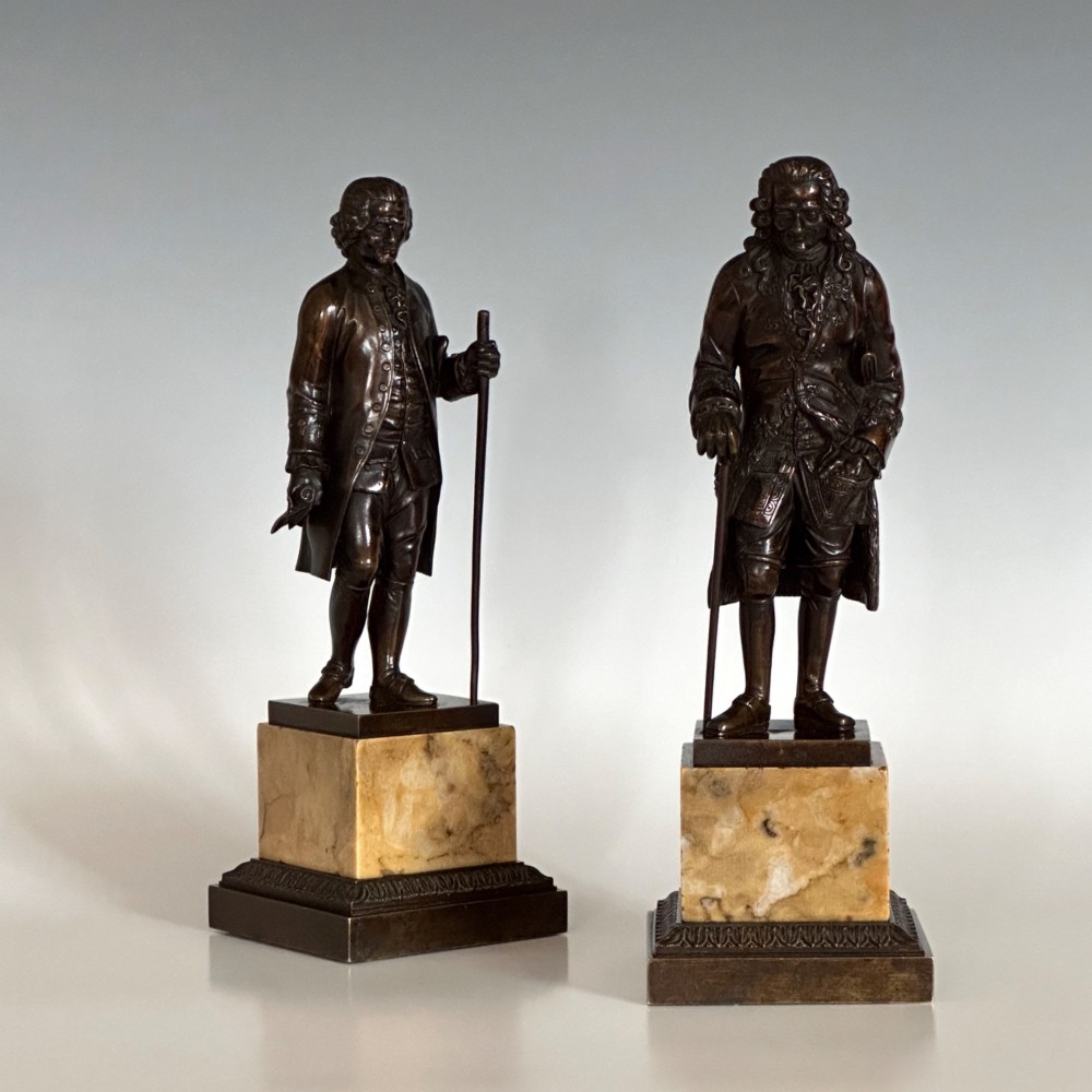 A pair of 19th-century French Restauration period patinated bronze statues of Voltaire and Rousseau mounted on yellow marble bases. View V