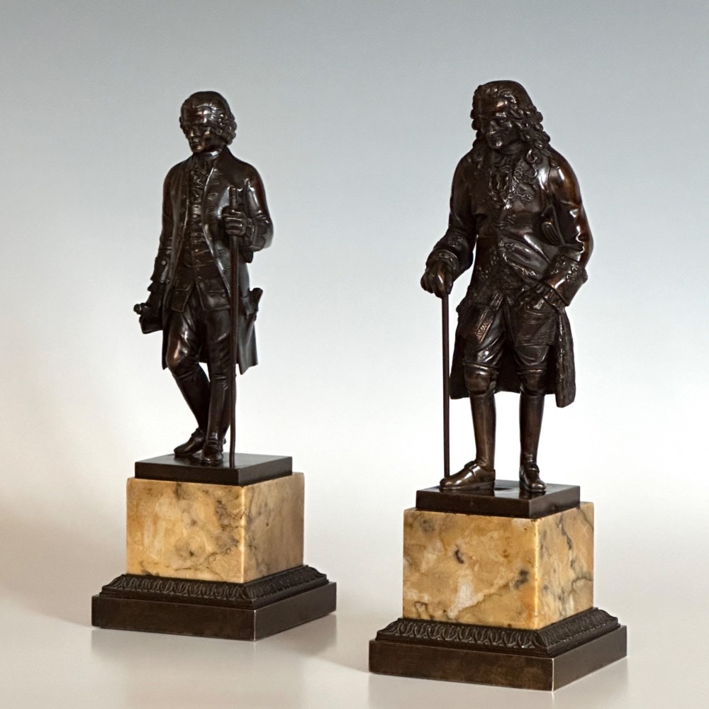 A pair of 19th-century French Restauration period patinated bronze statues of Voltaire and Rousseau mounted on yellow marble bases. View VI