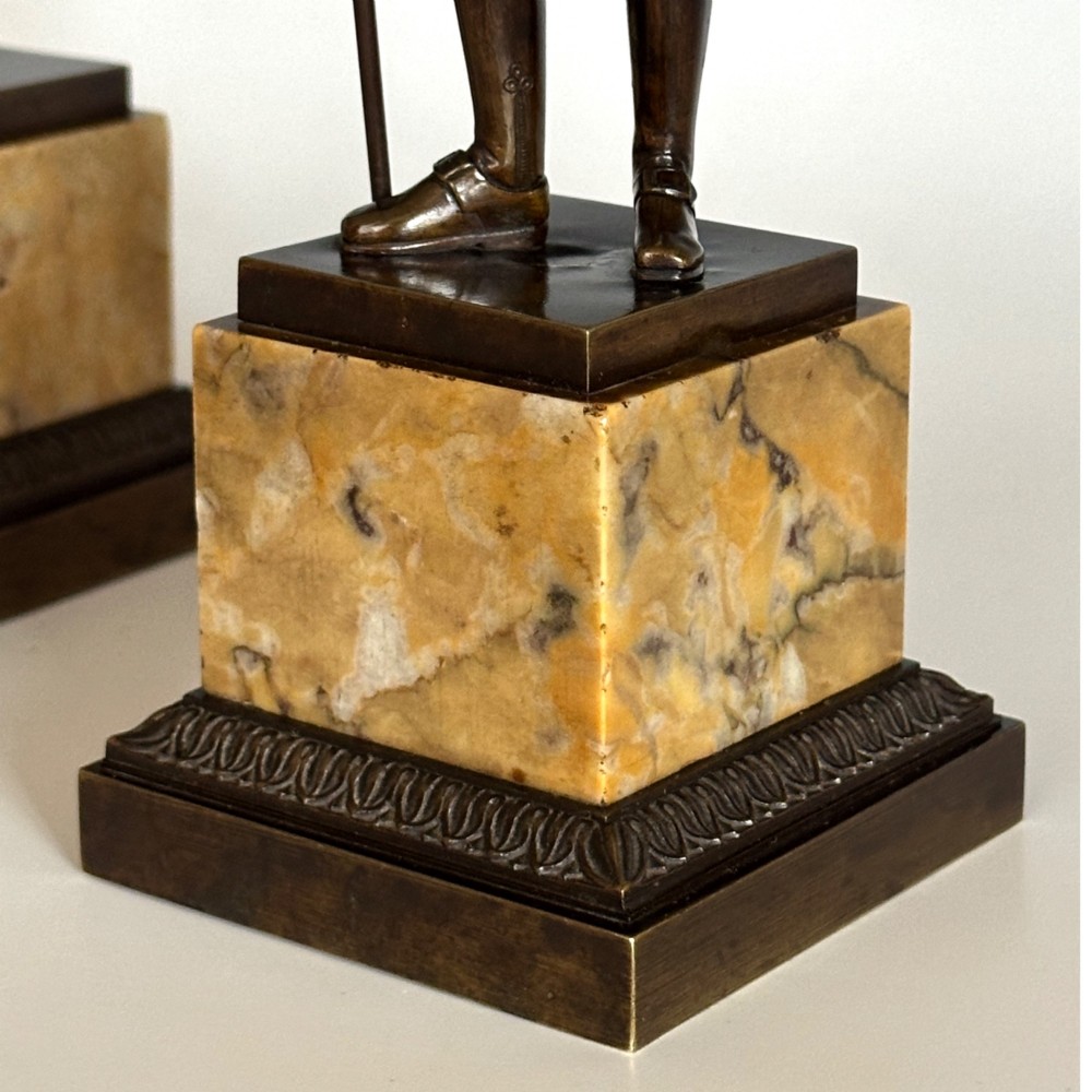 A pair of 19th-century French Restauration period patinated bronze statues of Voltaire and Rousseau mounted on yellow marble bases. View VII