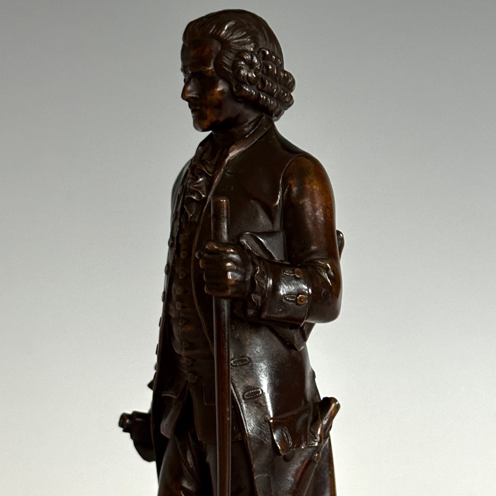 A pair of 19th-century French Restauration period patinated bronze statues of Voltaire and Rousseau mounted on yellow marble bases. View VIII