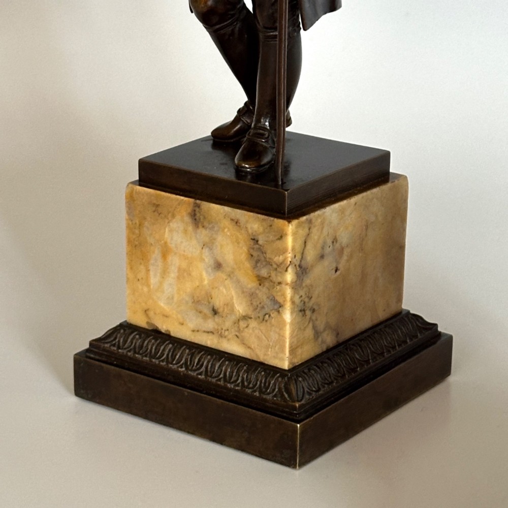 A pair of 19th-century French Restauration period patinated bronze statues of Voltaire and Rousseau mounted on yellow marble bases. View IX