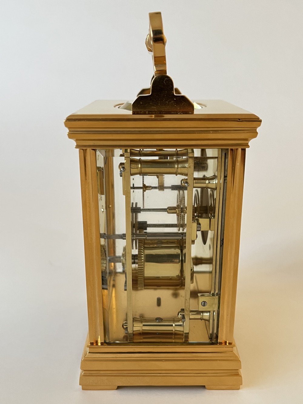 An antique French gilt brass carriage clock featuring a top folding handle, glass side panels, and a hand-painted dial with bird and floral motifs. View V
