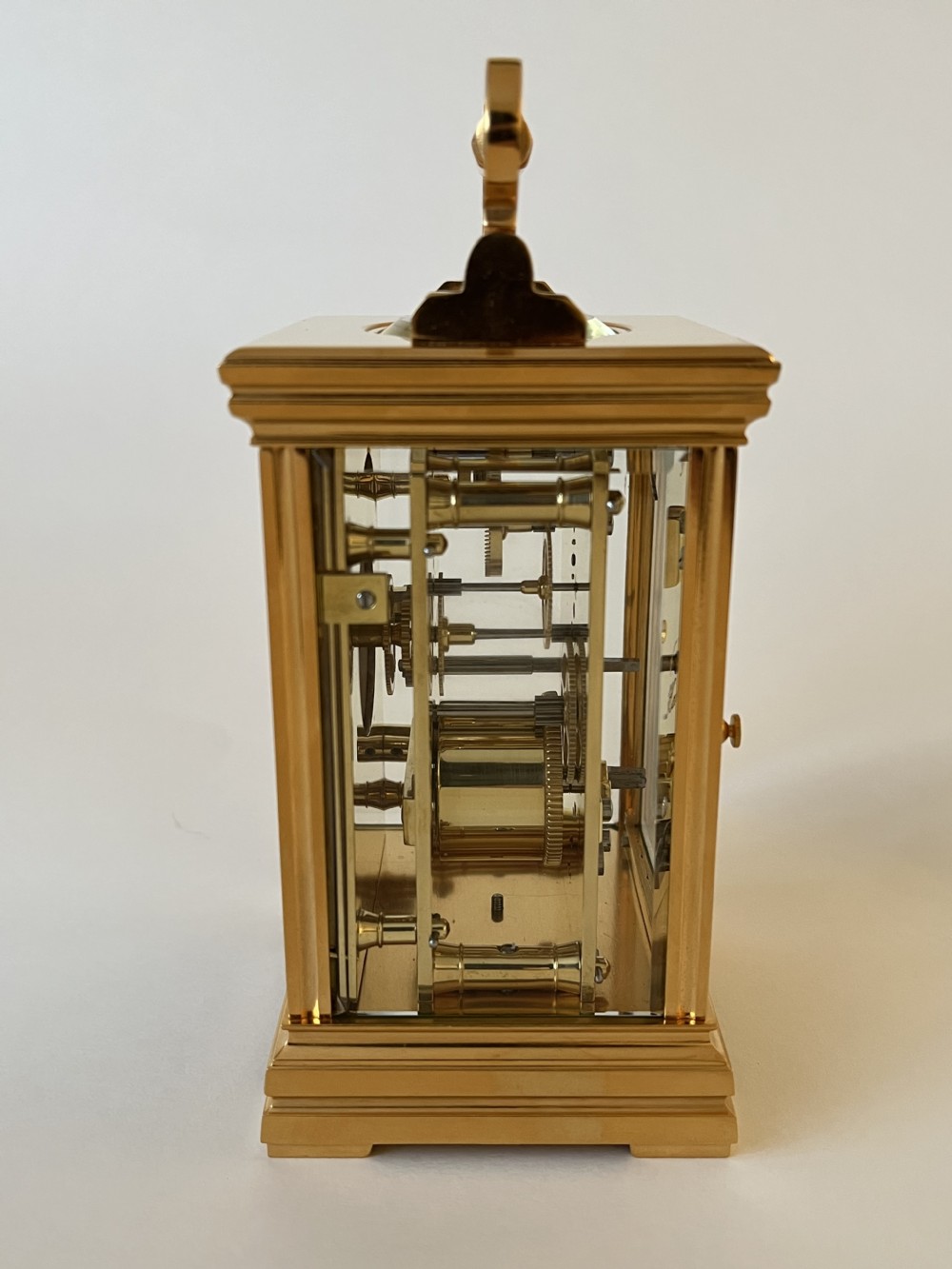An antique French gilt brass carriage clock featuring a top folding handle, glass side panels, and a hand-painted dial with bird and floral motifs. View VI