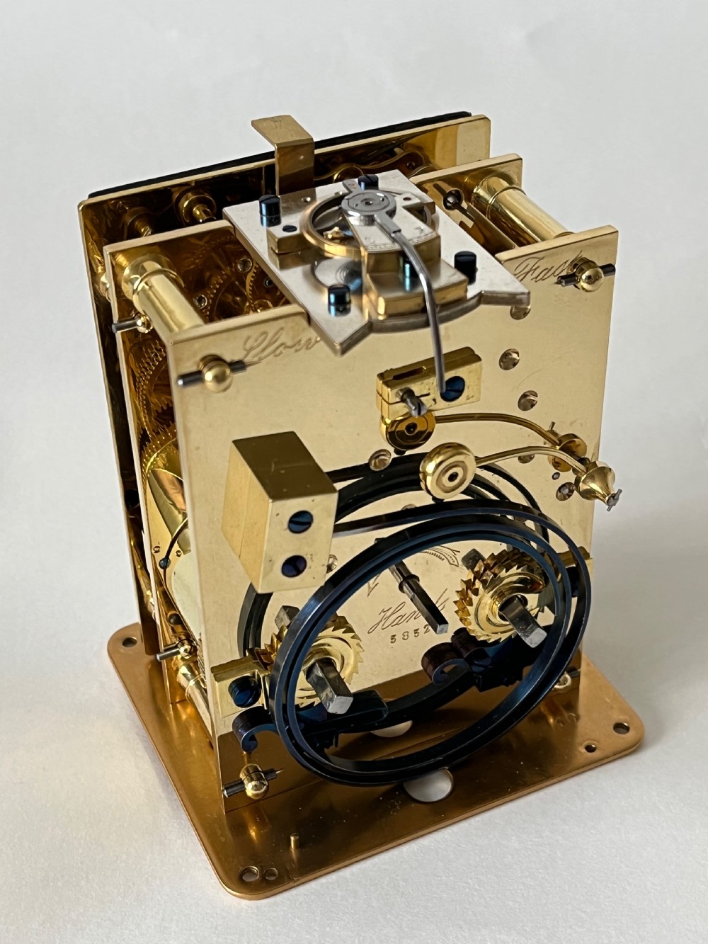A rectangular gilt brass French repeating carriage clock with a top handle, glass side panels, and a white enamel dial with black Roman numerals. View VII