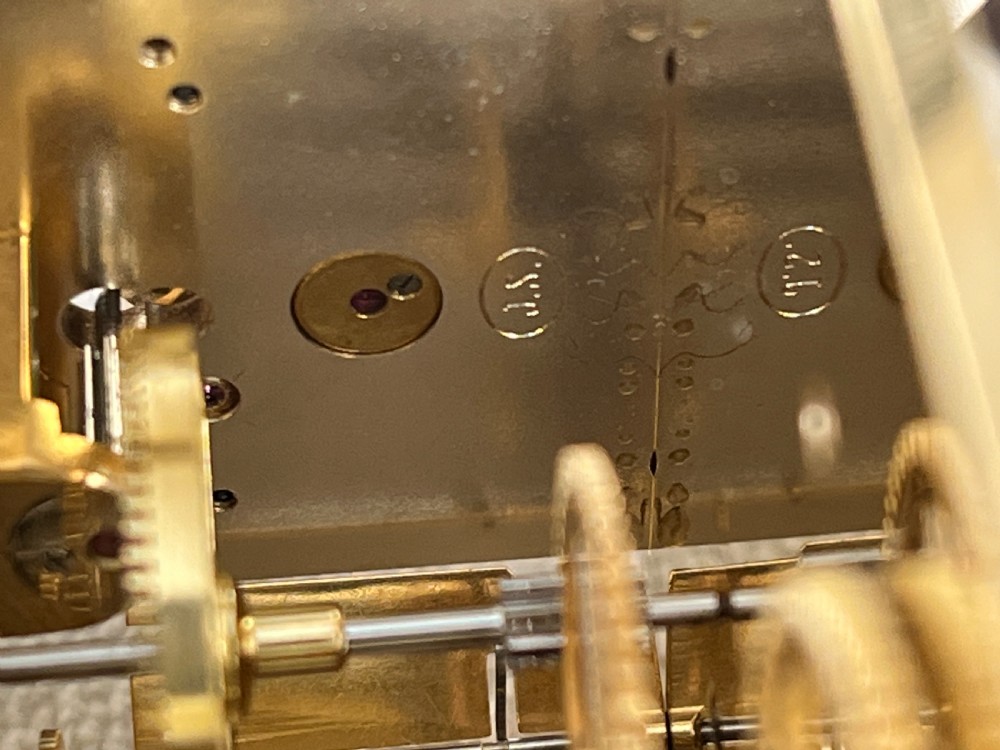 A rectangular gilt brass French repeating carriage clock with a top handle, glass side panels, and a white enamel dial with black Roman numerals. View IX
