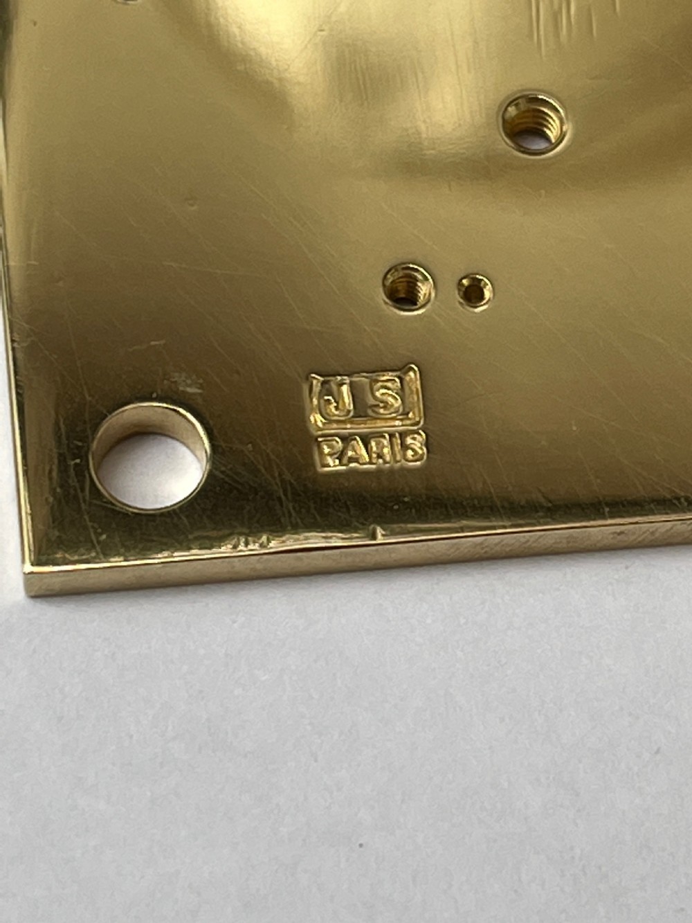 A rectangular gilt brass French repeating carriage clock with a top handle, glass side panels, and a white enamel dial with black Roman numerals. View X