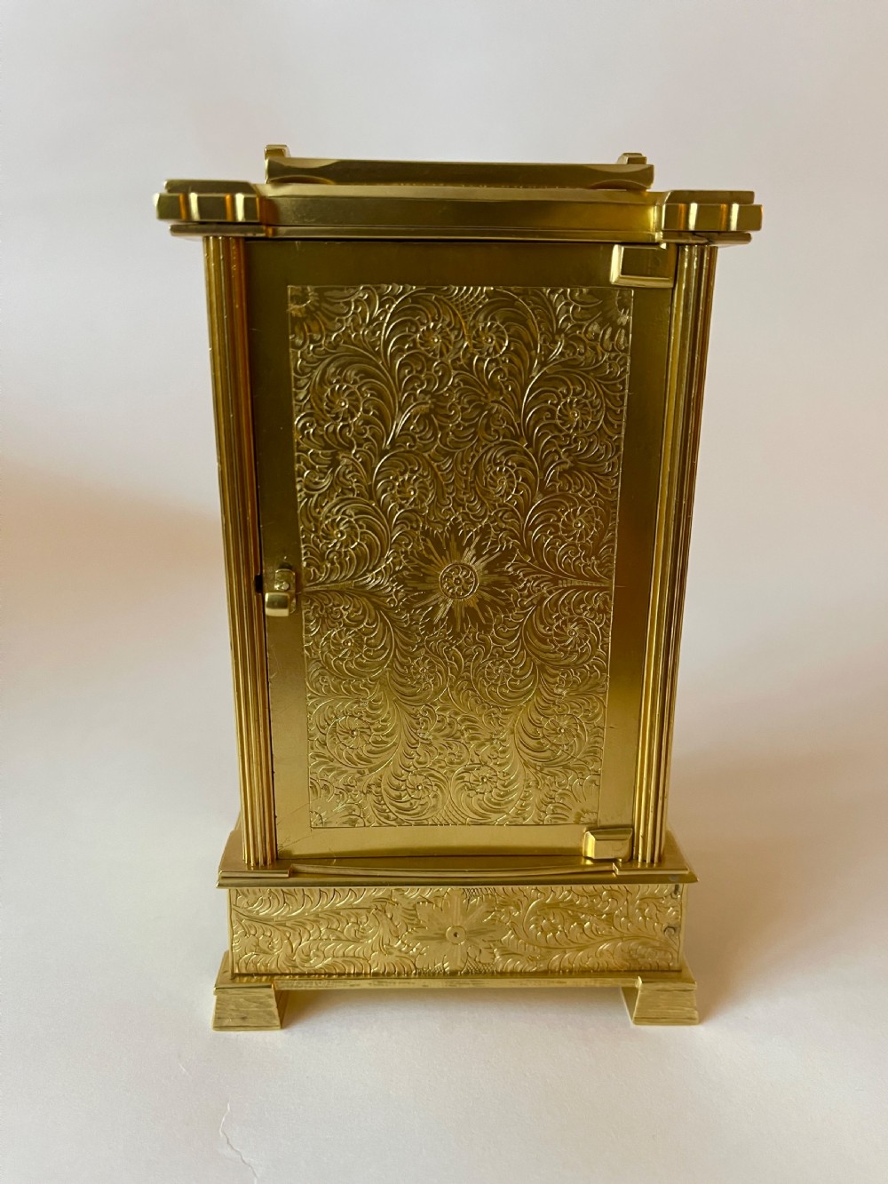 An engraved gilt brass Victorian English fusee carriage clock featuring Roman numerals and a folding carrying handle. View II