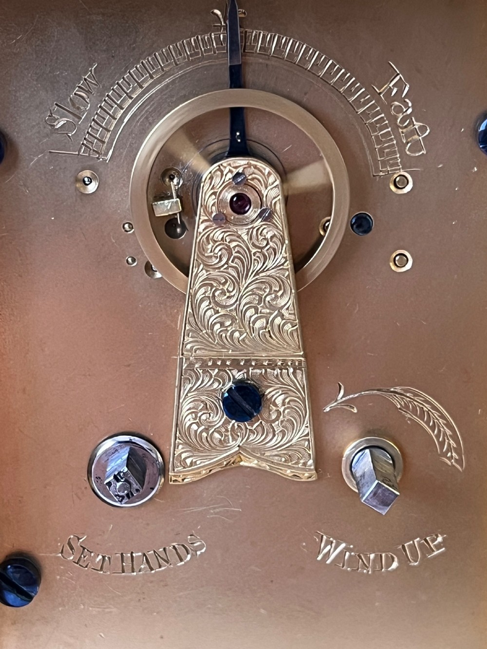 An engraved gilt brass Victorian English fusee carriage clock featuring Roman numerals and a folding carrying handle. View VIII
