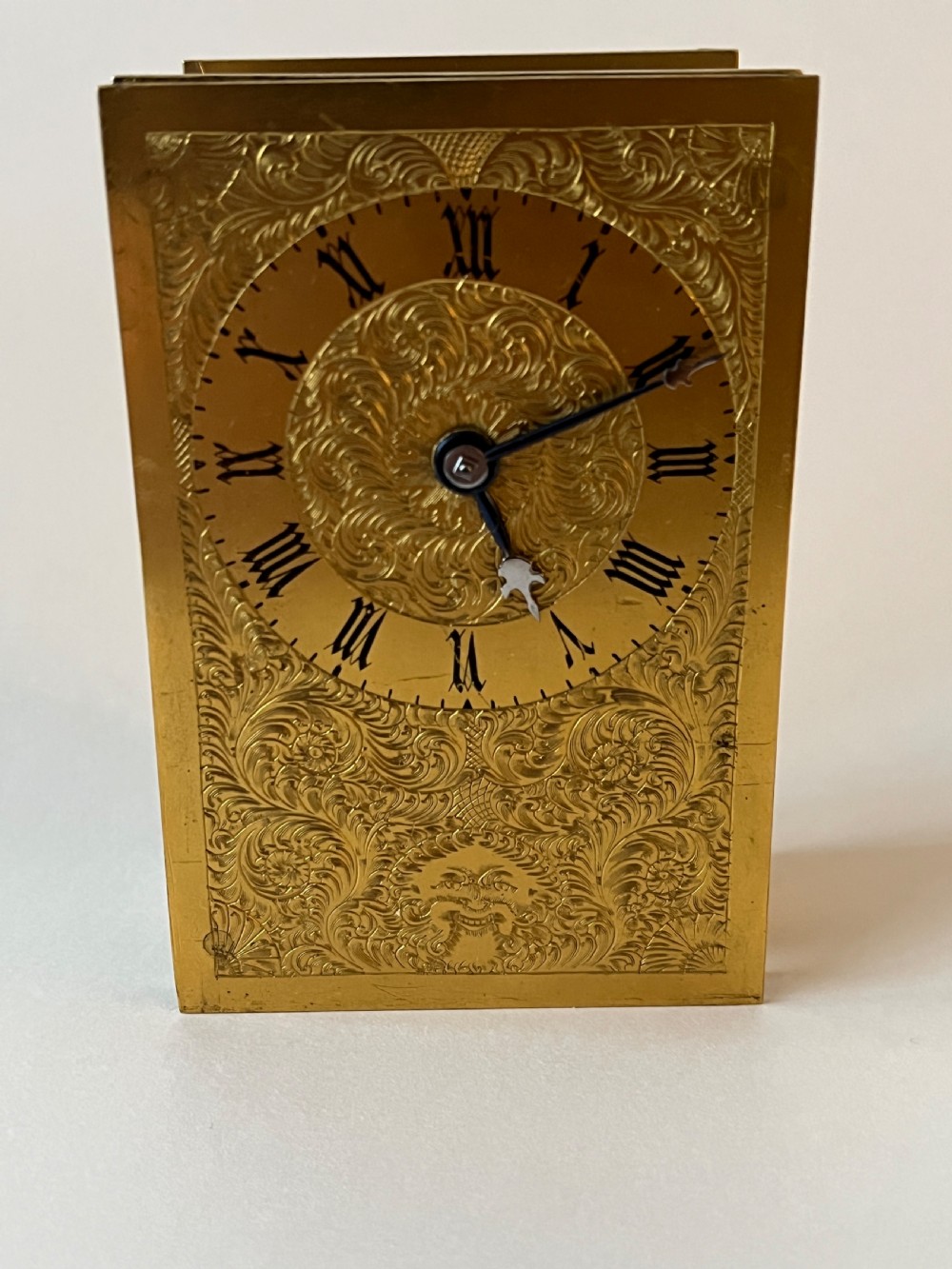 An engraved gilt brass Victorian English fusee carriage clock featuring Roman numerals and a folding carrying handle. View IX