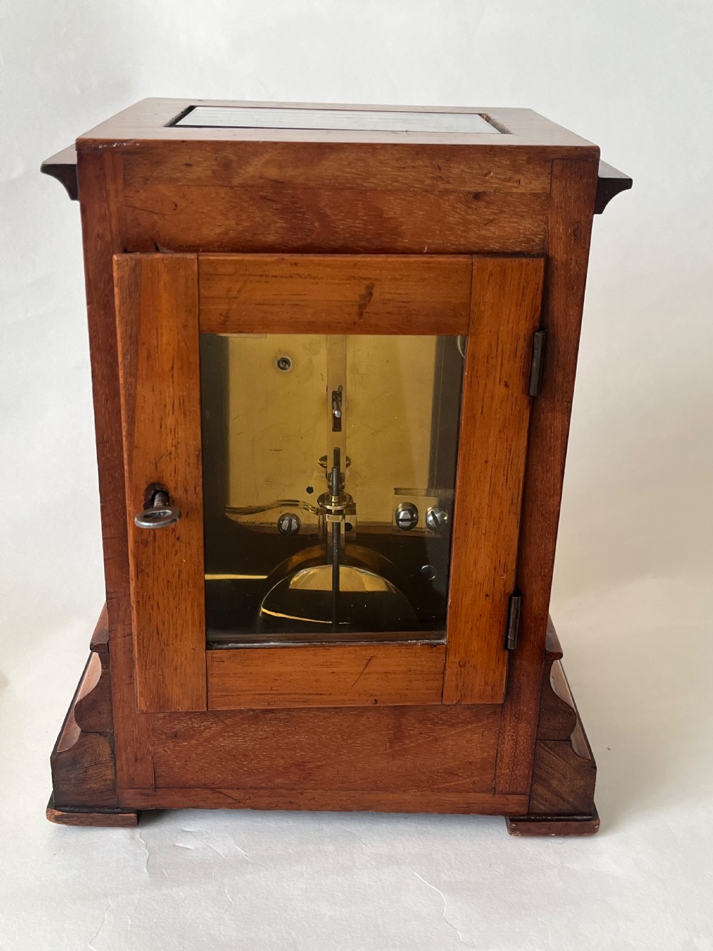 A Victorian mahogany library clock featuring a square timber case with a silvered engraved dial, black Roman numerals, and a key visible on the side. View II